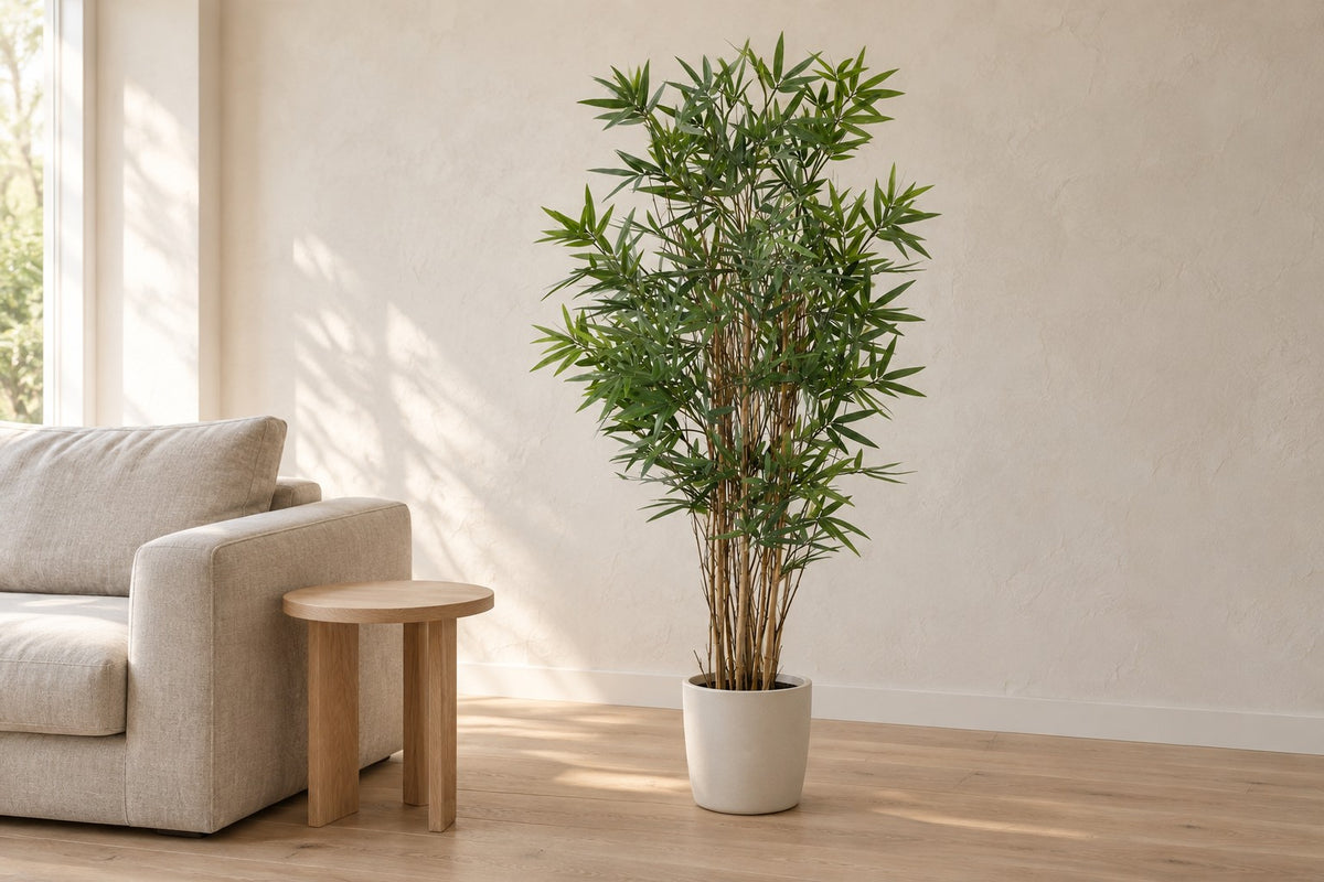Kunstplant Bamboe van 144 cm in een witte keramische pot in een lichte woonkamer