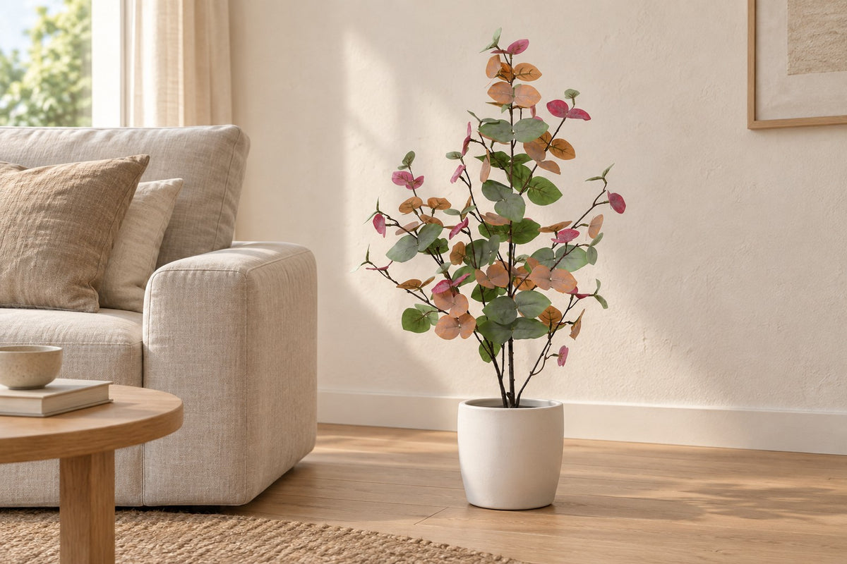 Kunstplant Eucalyptus gekleurd van 86 cm in een witte keramische pot in een lichte woonkamer