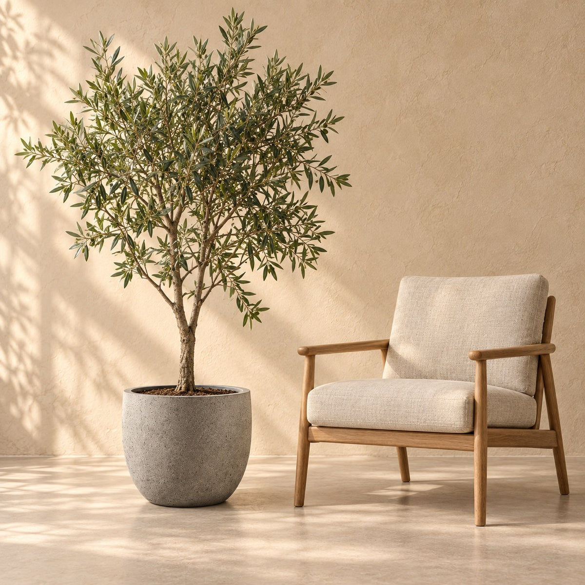 Ziertopf grigio new egg natural concrete Ø45 x H38 cm, in Originalgröße neben einem Sessel