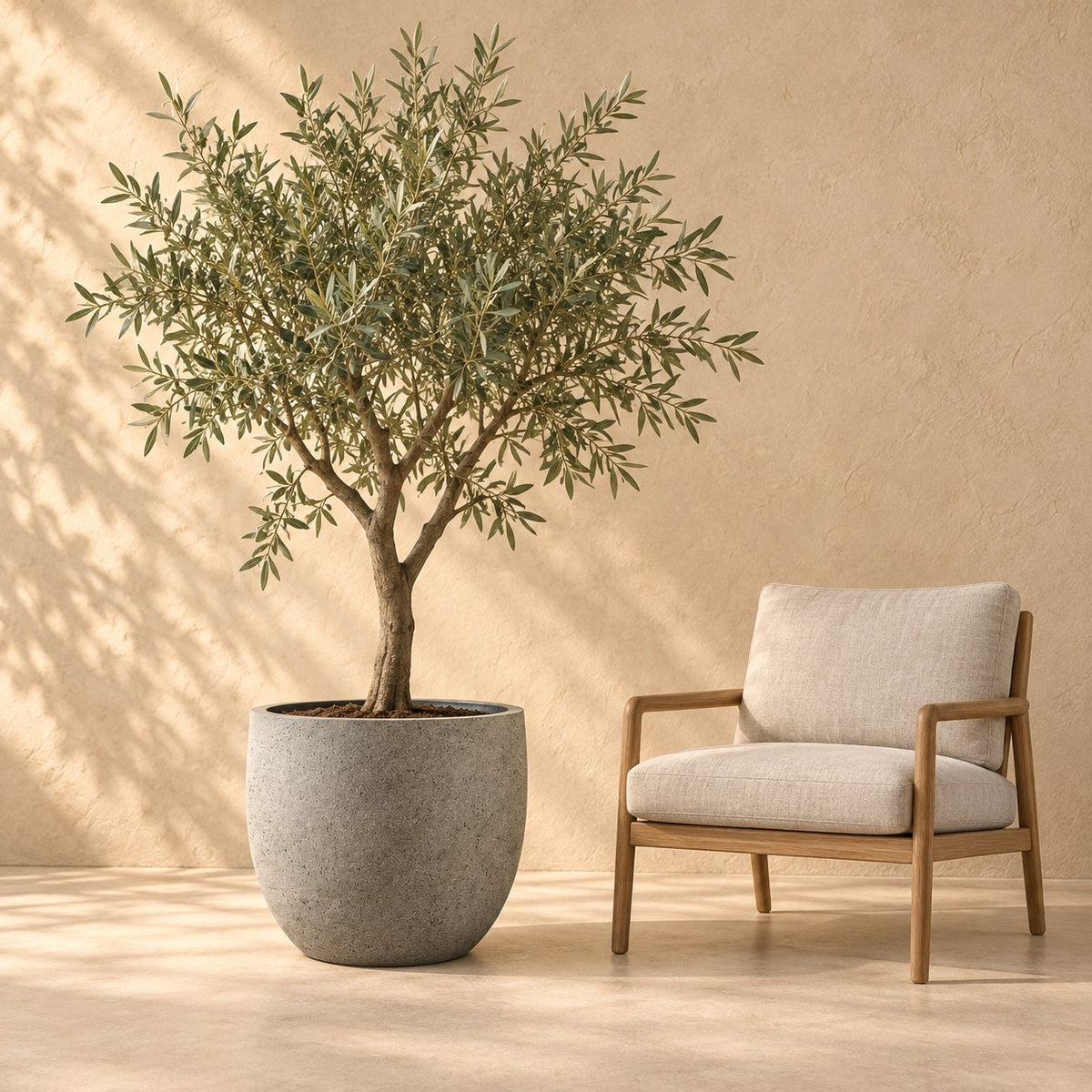 Dekorativ potte grigio new egg natural concrete Ø65 x H54 cm, i naturlig størrelse ved siden af en lænestol