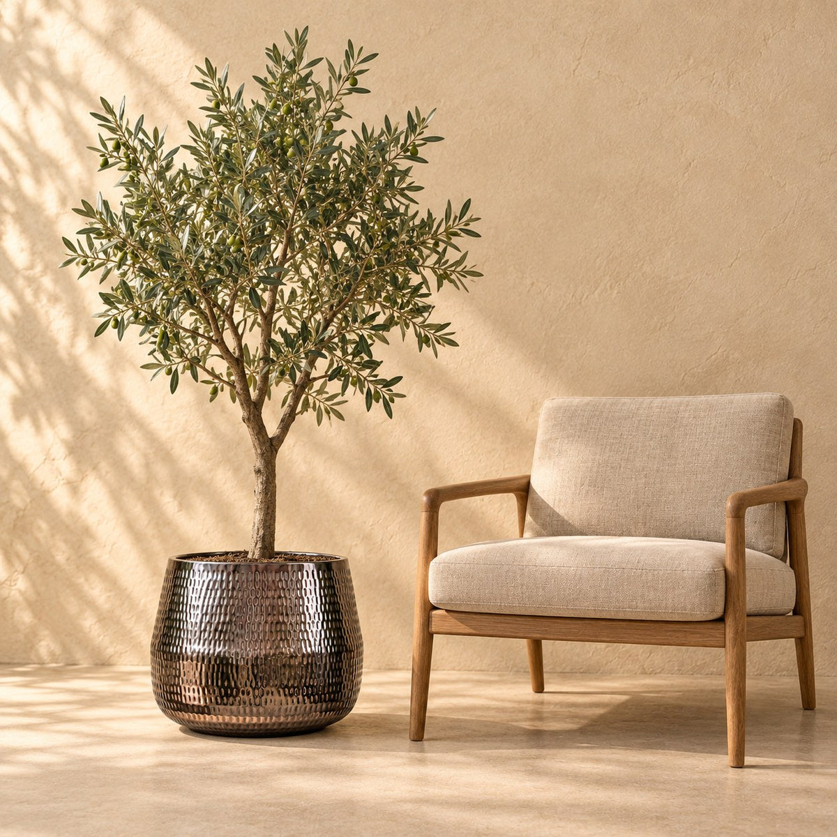 Pot décoratif Jenna plomb Ø46 x H38 cm, à taille réelle à côté d’un fauteuil