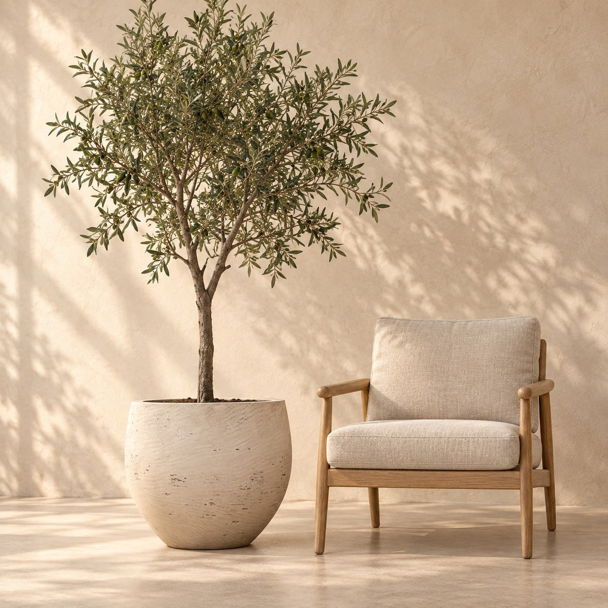 Pot décoratif Jumbo Orb Beige Washed Ø53 x H45 cm, à taille réelle à côté d’un fauteuil