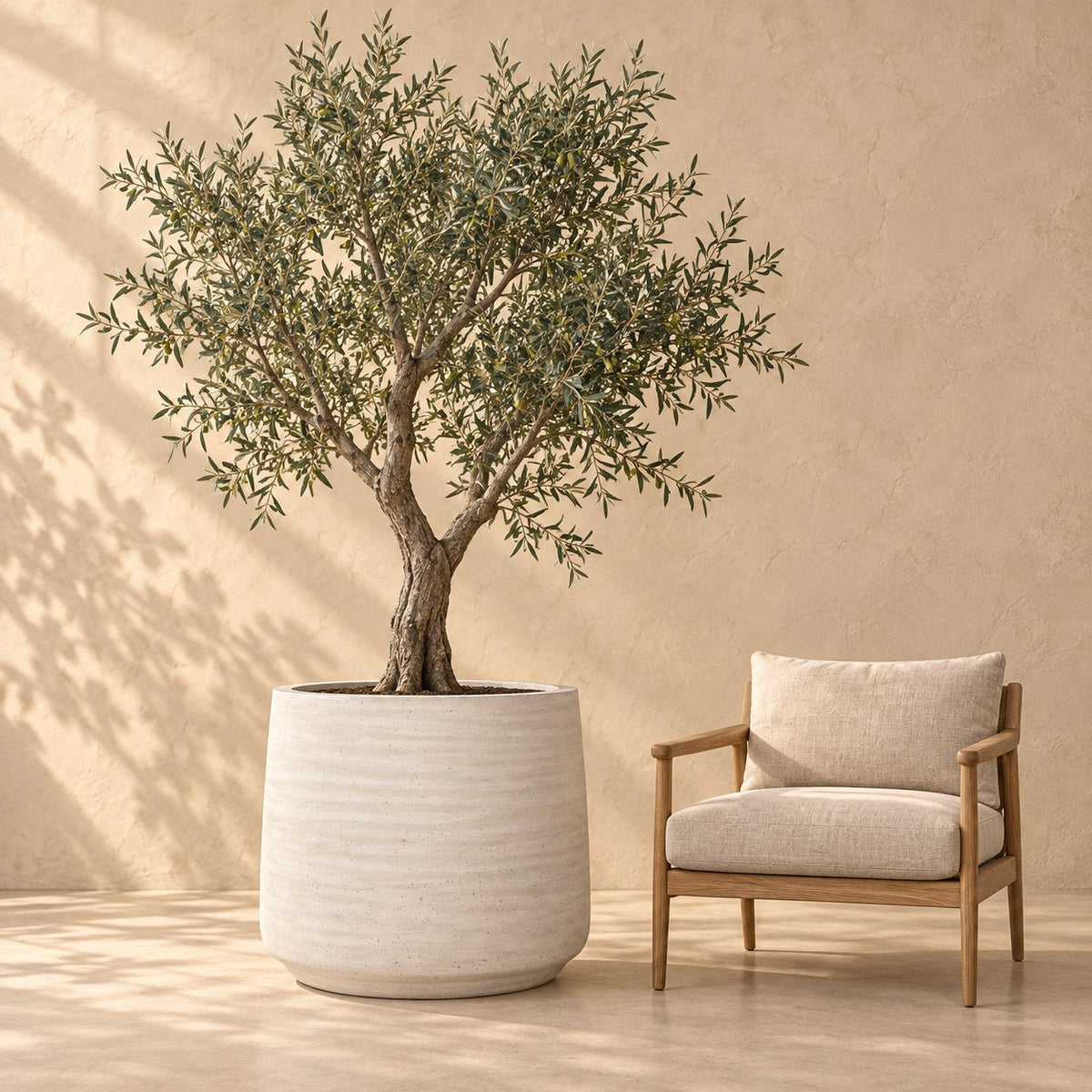 Pot décoratif Jumbo Patt Ivoire Washed Ø93 x H77 cm, à taille réelle à côté d’un fauteuil