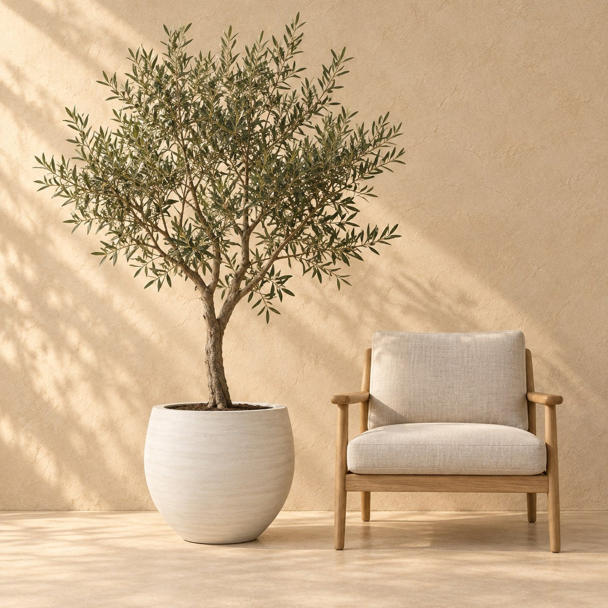 Pot décoratif Orb Ivoire Washed Ø53 x H45 cm, à taille réelle à côté d’un fauteuil