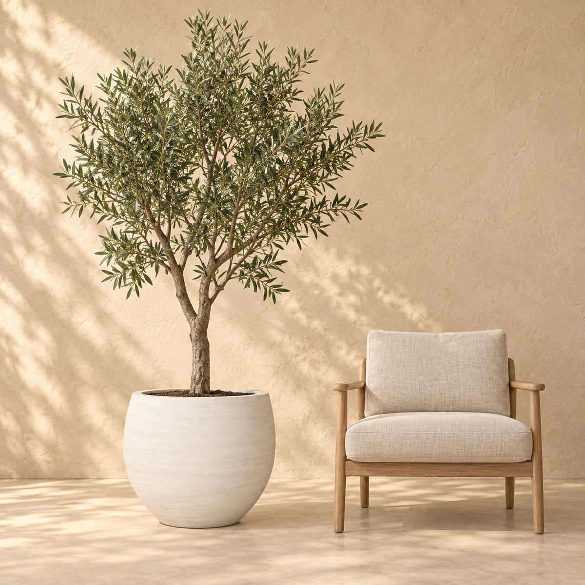 Pot décoratif Orb Ivoire Washed Ø69 x H57 cm, à taille réelle à côté d’un fauteuil