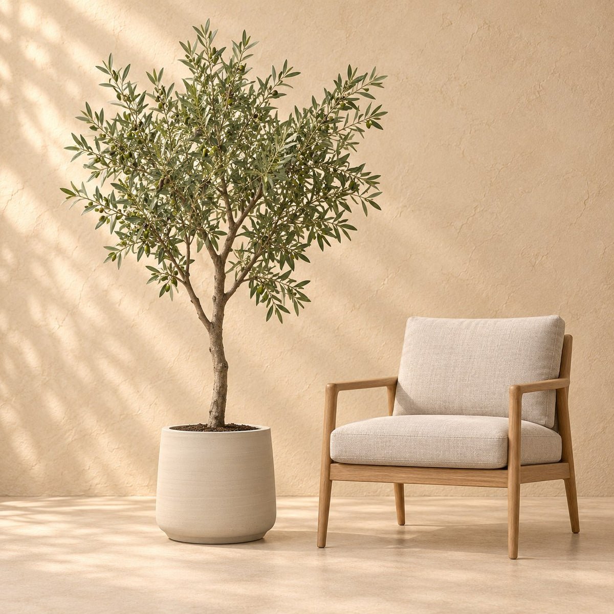 Dekorativ potte Patt Beige Washed Ø45 x H38 cm, i naturlig størrelse ved siden af en lænestol