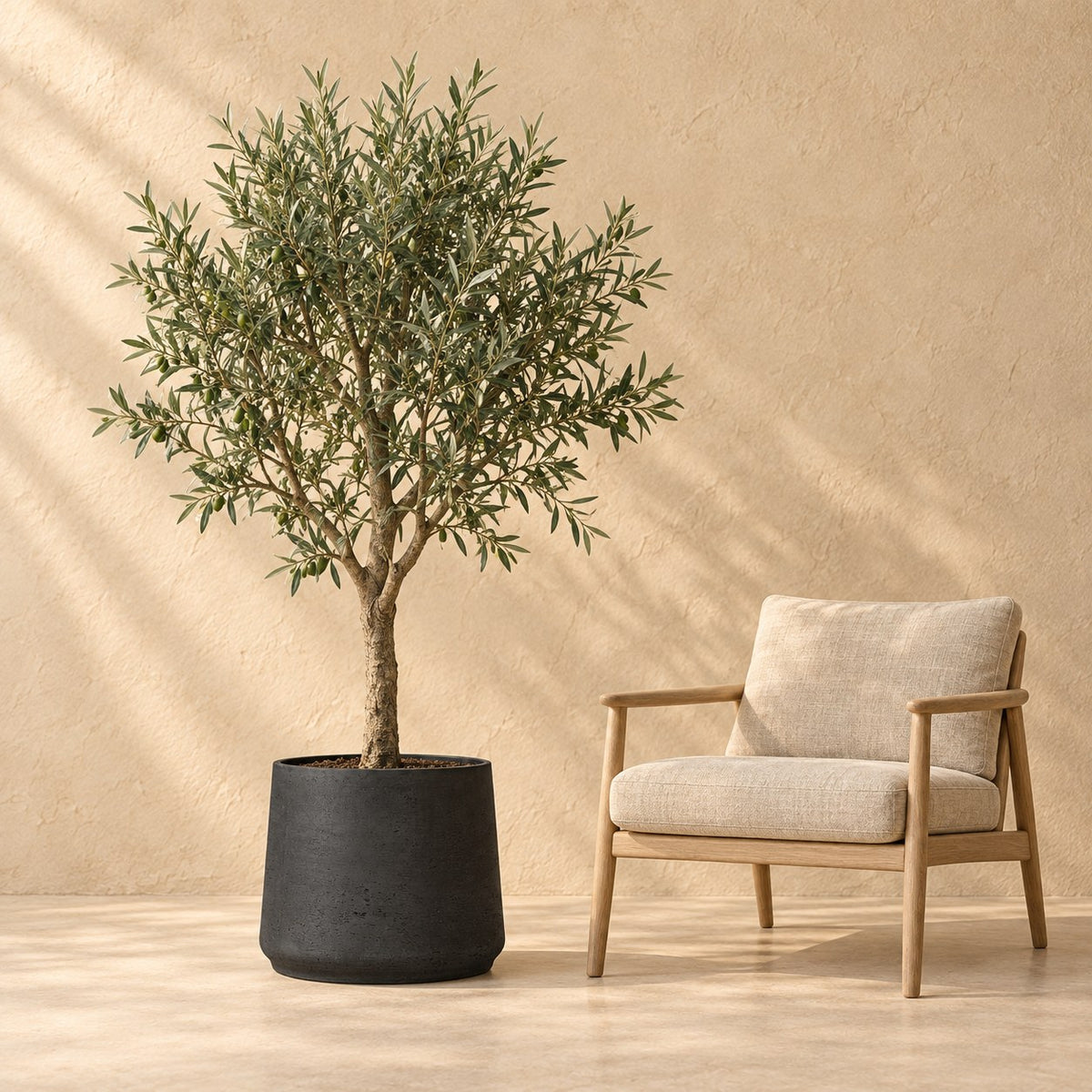 Pot décoratif Patt Black Washed Ø45 x H38 cm, à taille réelle à côté d’un fauteuil